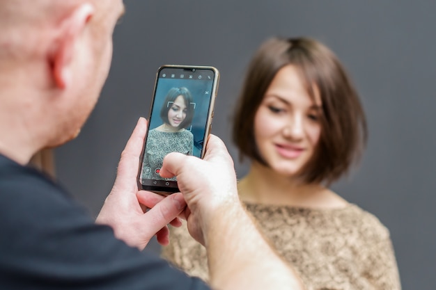 Joven fotografiando a una niña