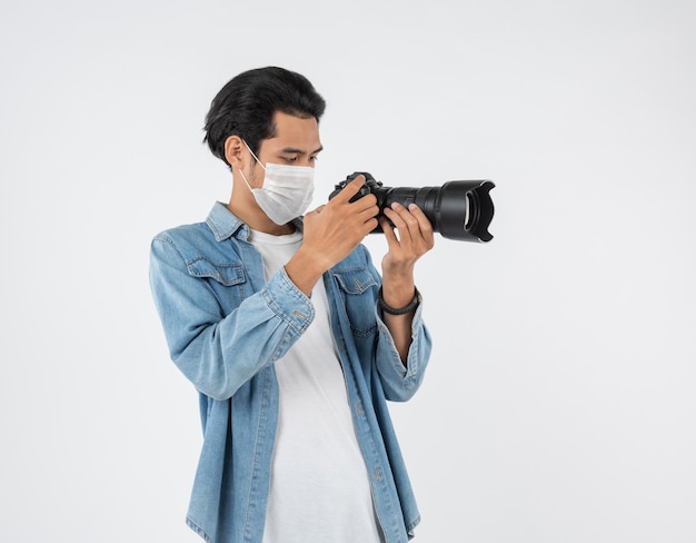 Joven fotógrafo asiático con máscara protectora