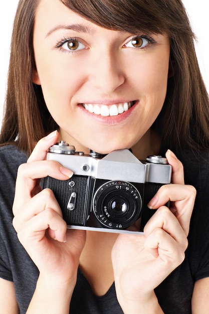 un joven fotógrafo feliz posando con su cámara vintage