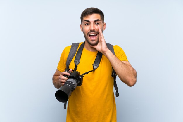 Joven fotógrafo gritando con la boca abierta