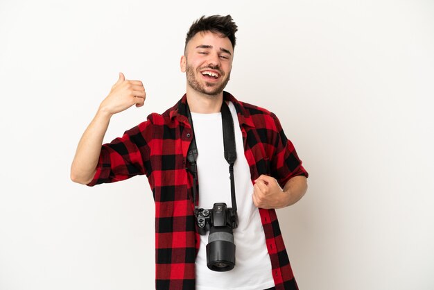 Joven fotógrafo hombre caucásico aislado sobre fondo blanco haciendo gesto de guitarra