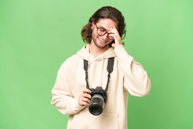 Joven fotógrafo hombre sobre fondo aislado riendo