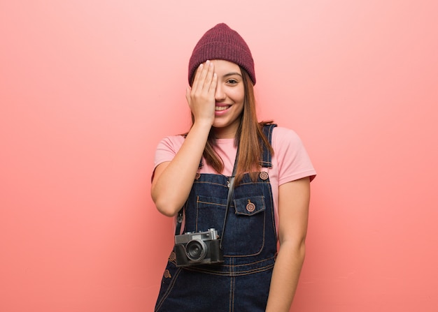 Joven fotógrafo lindo mujer gritando feliz y cubriéndose la cara con la mano