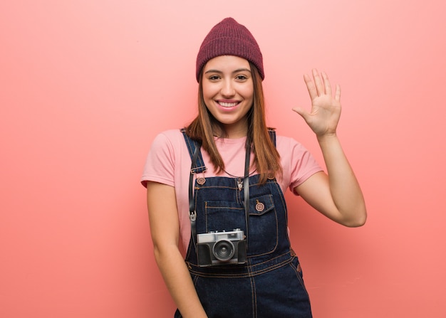 Joven fotógrafo lindo mujer mostrando número cinco