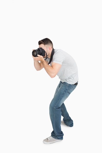 Joven fotógrafo masculino con cámara fotográfica