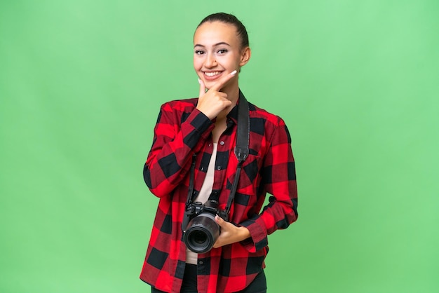 Joven fotógrafo mujer árabe sobre fondo aislado sonriendo