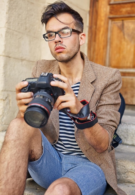 Joven fotógrafo piensa en el siguiente cuadro