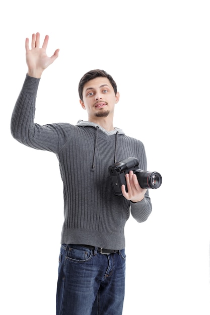 Foto joven fotógrafo profesional exitoso en camisa con cámara digital dslr saludando hola aislado sobre fondo blanco.