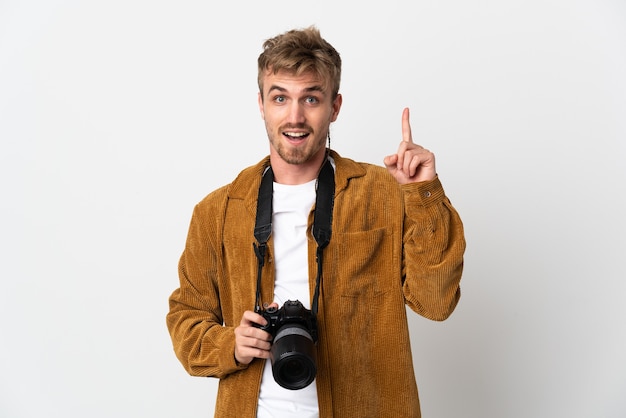 Joven fotógrafo rubio aislado sobre fondo blanco apuntando hacia una gran idea