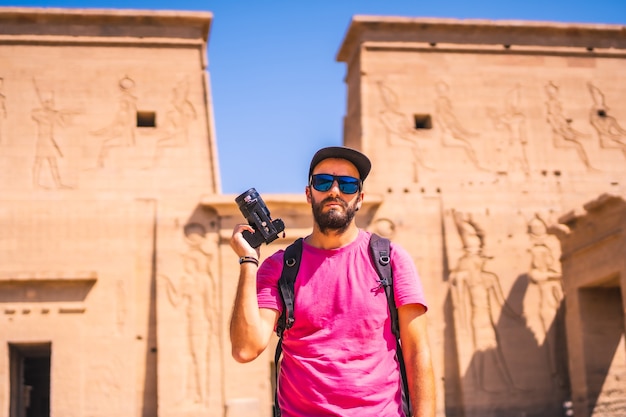 Un joven fotógrafo en el templo de filae, una construcción grecorromana, un templo dedicado a isis, diosa del amor. asuán. egipcio