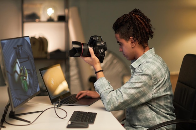 Foto joven fotógrafo usando laptop en su lugar de trabajo