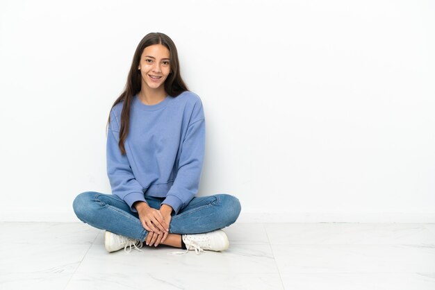Foto joven francesa sentada en el suelo riendo