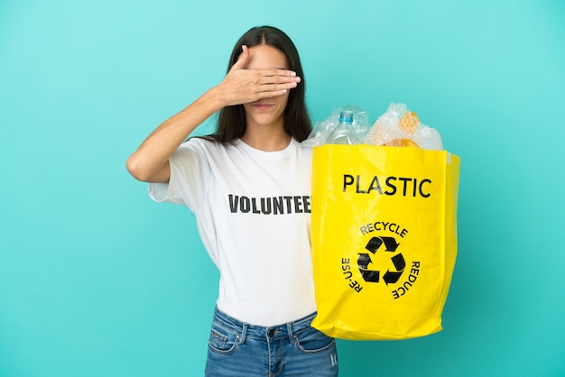 Foto joven francesa sosteniendo una bolsa llena de botellas de plástico para reciclar cubriendo los ojos con las manos. no quiero ver algo