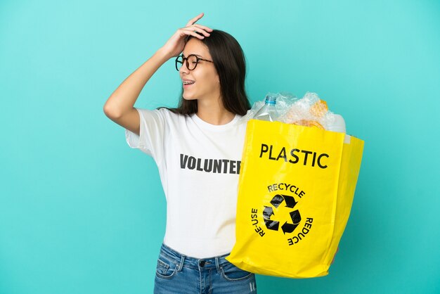 Joven francesa sosteniendo una bolsa llena de botellas de plástico para reciclar se ha dado cuenta de algo y tiene la intención de la solución