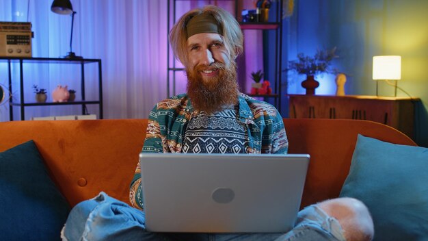 Joven freelance comienza a trabajar en una computadora portátil envía mensajes hace compras en línea en casa