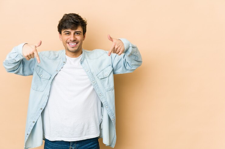 Foto joven fresco apunta hacia abajo con los dedos, sentimiento positivo