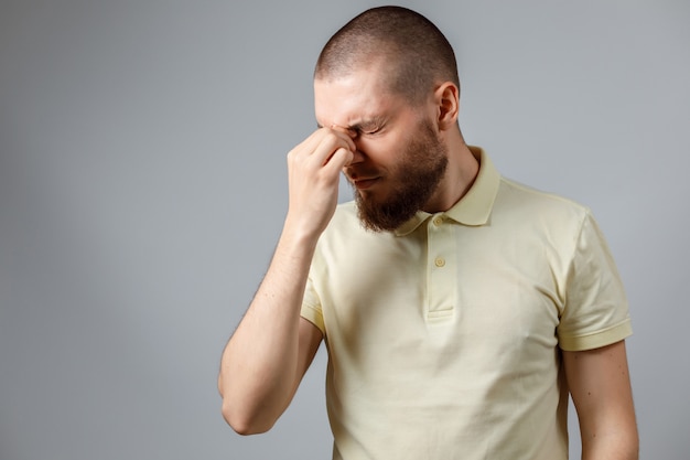 Joven frotando sus ojos en blanco