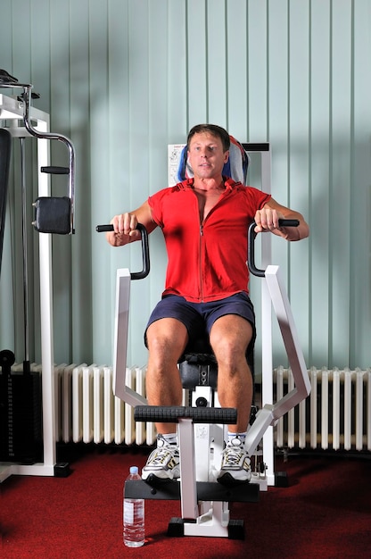 Un joven fuerte hace ejercicio en el gimnasio