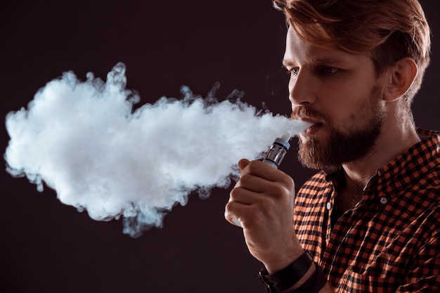 Joven fumando cigarrillo electrónico