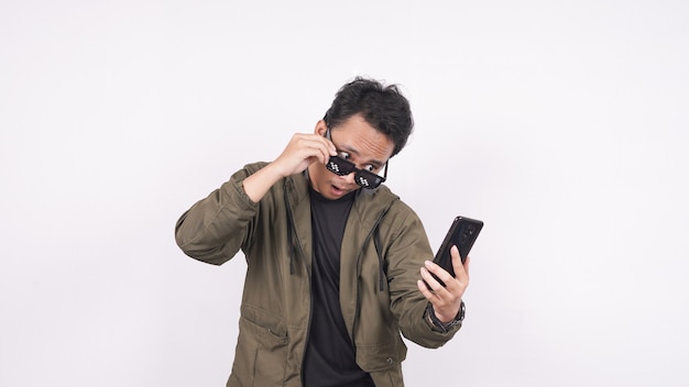 El joven con gafas en un espacio en blanco con teléfono