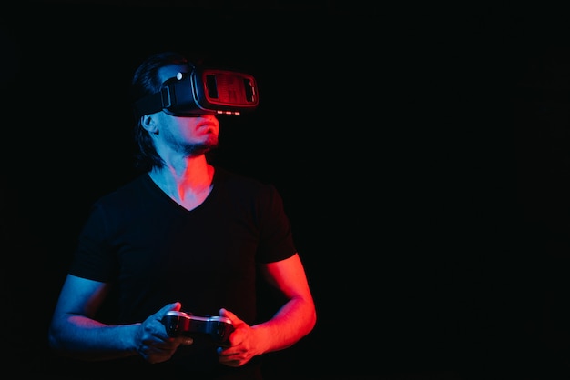 Un joven con gafas de realidad virtual está jugando videojuegos. con espacio para texto