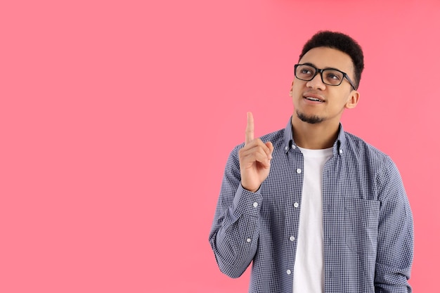 Joven con gafas sobre fondo rosa