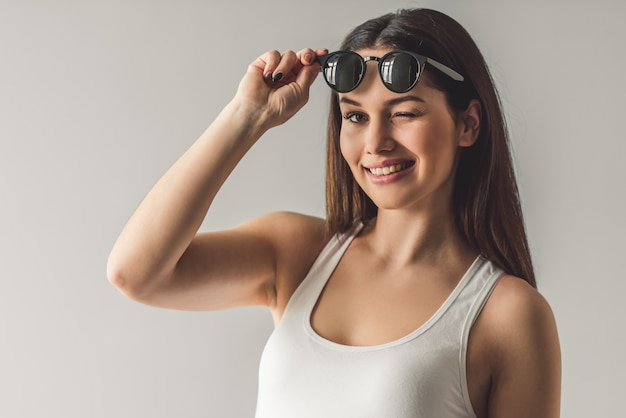 joven en gafas de sol está guiñando un ojo