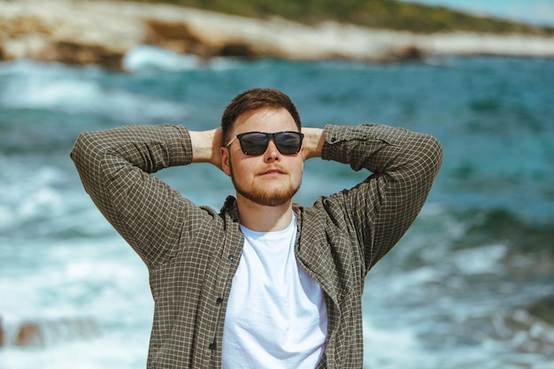 Joven con gafas de sol con retrato de barba en la playa