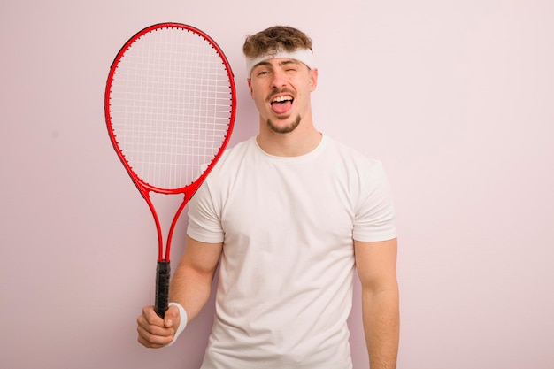 Joven genial con actitud alegre y rebelde bromeando y sacando la lengua concepto de tenis