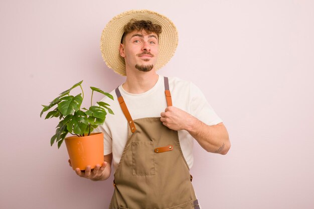 Joven genial que parece arrogante, exitoso, positivo y orgulloso jardinero y planta