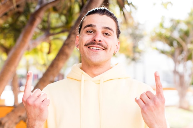 Foto un joven genial que se siente asombrado y con la boca abierta apuntando hacia arriba con una mirada de asombro y sorpresa.