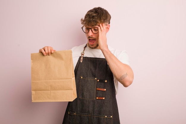 Joven genial que se siente feliz, emocionado y sorprendido, repartidor y comida rápida