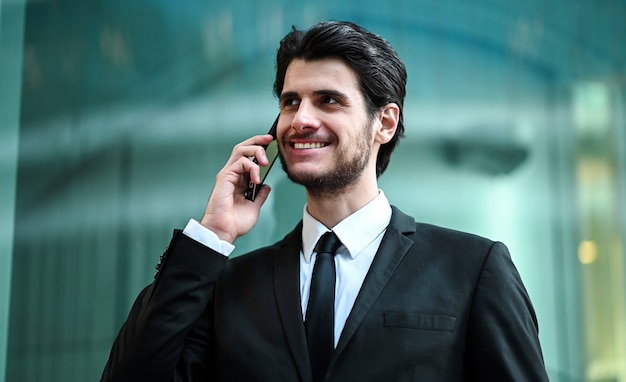 Joven gerente en el teléfono al aire libre en un entorno urbano