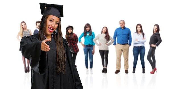 Joven graduada, mujer negra con trenzas para saludar a alguien o gesticular para ayudar, feliz y emocionada