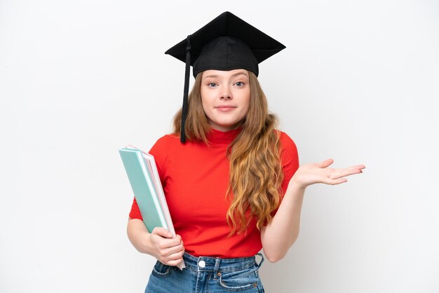 Joven graduada universitaria aislada de fondo blanco que tiene dudas mientras levanta las manos