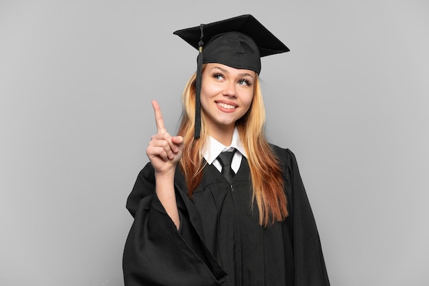 Joven graduada universitaria sobre antecedentes aislados apuntando hacia una gran idea