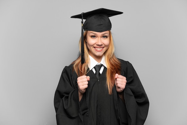 Joven graduada universitaria sobre antecedentes aislados celebrando una victoria en la posición ganadora