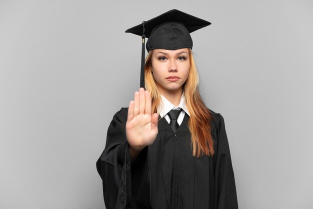 Joven graduada universitaria sobre antecedentes aislados haciendo gesto de parada