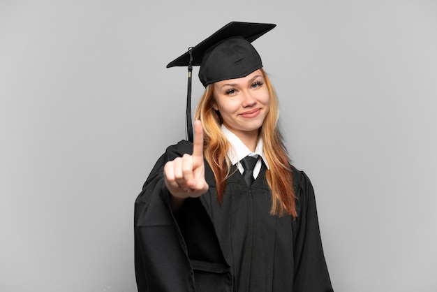 Joven graduada universitaria sobre antecedentes aislados mostrando y levantando un dedo