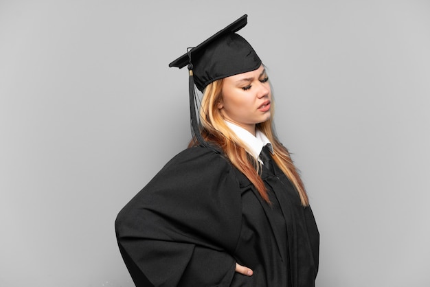 Joven graduada universitaria sobre antecedentes aislados que sufren de dolor de espalda por haber hecho un esfuerzo