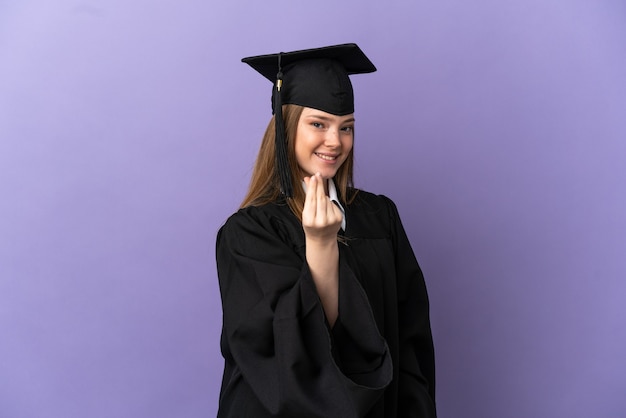 Joven graduado de la Universidad sobre fondo púrpura aislado haciendo gesto de dinero