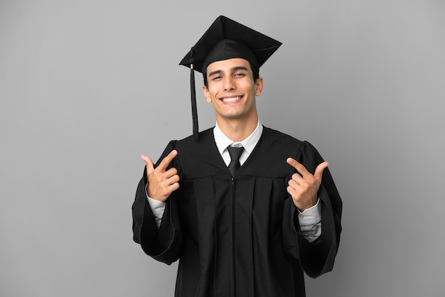 Joven graduado universitario argentino aislado de fondo gris orgulloso y satisfecho de sí mismo