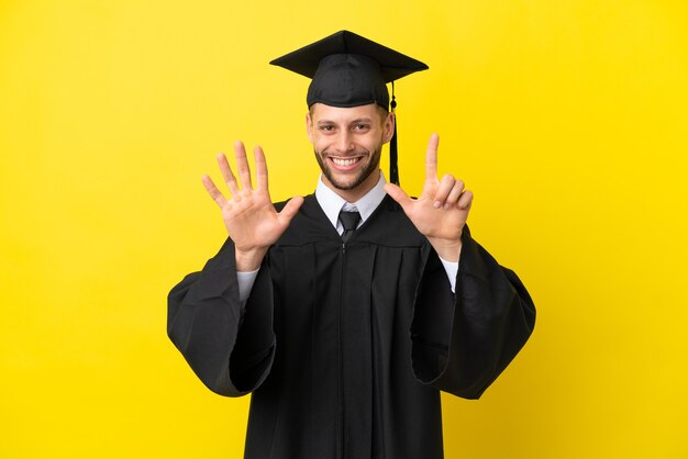 Joven graduado universitario hombre caucásico aislado sobre fondo amarillo contando siete con los dedos