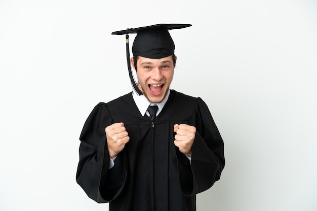 Joven graduado universitario ruso aislado sobre fondo blanco celebrando una victoria en la posición ganadora