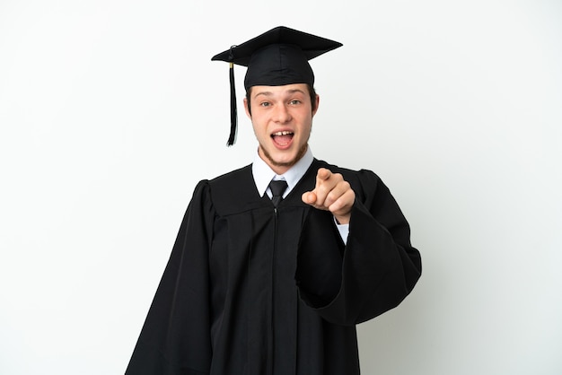 Joven graduado universitario ruso aislado sobre fondo blanco sorprendido y apuntando hacia el frente