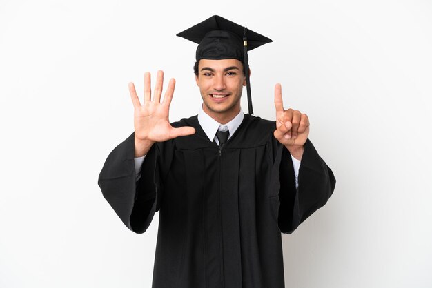 Joven graduado universitario sobre fondo blanco aislado contando seis con los dedos