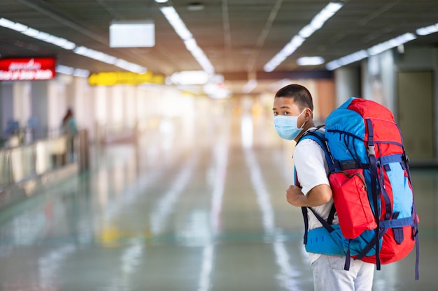 Foto un joven con una gran mochila en el aeropuerto listo para partir