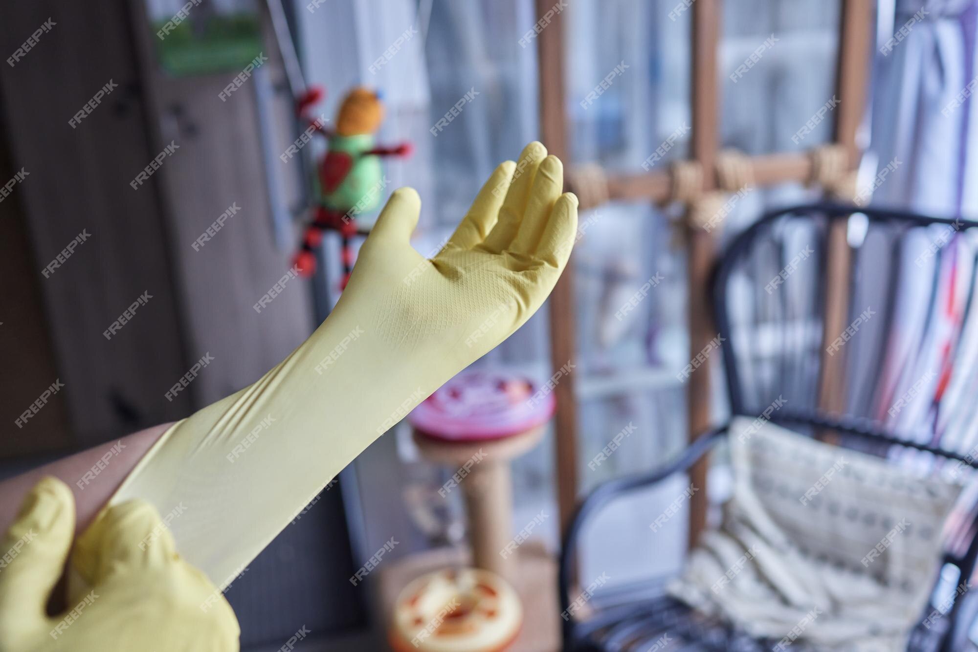 Joven con guantes de goma amarillos listo para limpiar