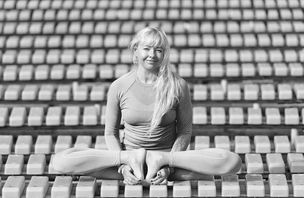 Una joven guapa haciendo asanas de yoga en el parque