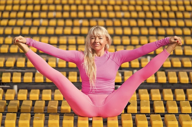 Una joven guapa haciendo asanas de yoga en el parque